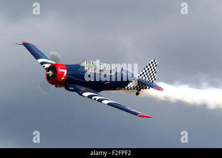 Vecchio svedese Saab Sk 16 elica da combattimento aereo battenti passato e mette fuori fumo in un air show Foto Stock