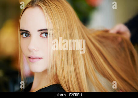 Close up ritratto donna con fragola capelli biondi in salone Foto Stock