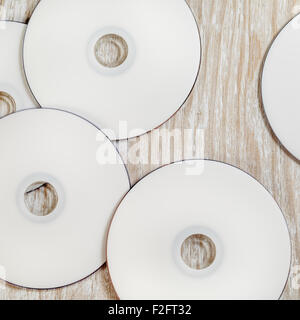 Blank printable CD e DVD su luce sullo sfondo di legno. Vista dall'alto. Foto Stock