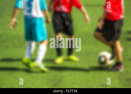 Ragazzi che giocano a calcio, defocussed sfocatura dello sfondo dello sport Foto Stock