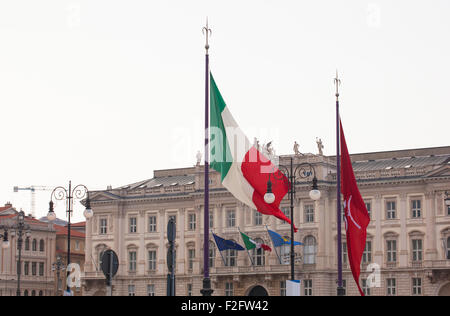 Vista di italiano e Trieste bandiere al vento Foto Stock