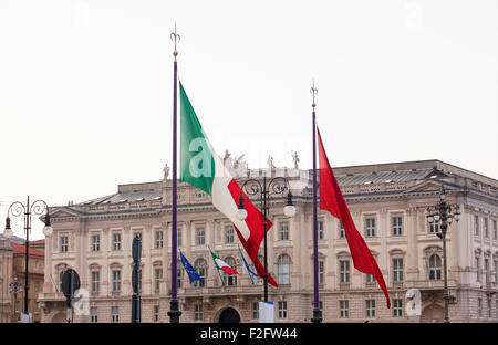 Vista di italiano e Trieste bandiere al vento Foto Stock