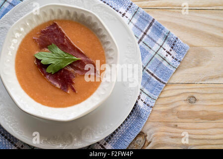 Il Gazpacho zuppa estiva nella vaschetta . Guarnito con prosciutto e prezzemolo Foto Stock