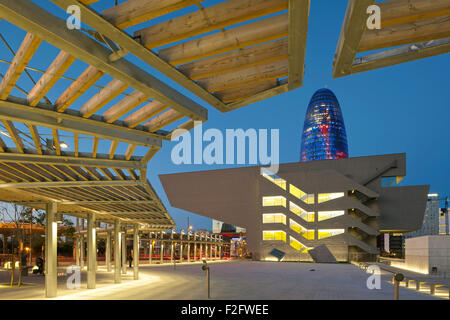 Crepuscolo elevazione con piazza pubblica e illuminato di museo. Museu del Disseny de Barcelona, Barcelona, Spagna. Architetto: farine di carne e di ossa Arquitecte Foto Stock