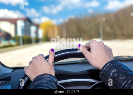 Mani femminili di conducente sul volante Foto Stock