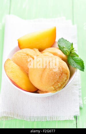 Il sorbetto di pesche fresche a fette di frutta e Menta in vaso bianco Foto Stock