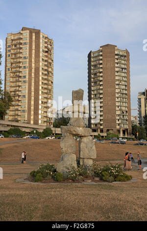 Inukshuk statua Stanley Park a Vancouver con blocchi di appartamenti in background Foto Stock