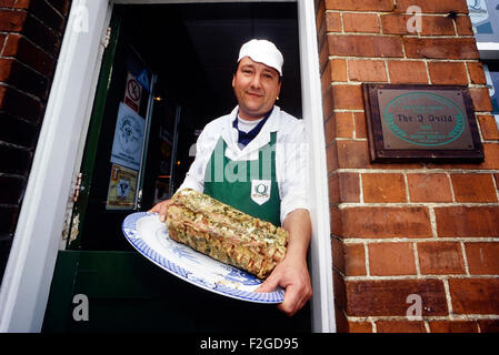 Lincolnshire indipendenti butcher tenendo una piastra di insaccati lombata. In Inghilterra. Regno Unito Foto Stock