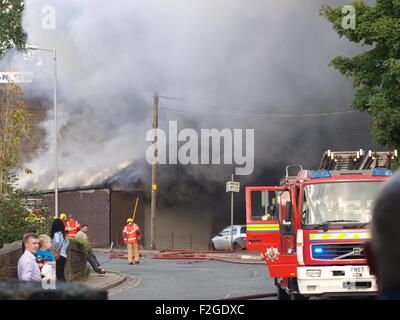 Mossley, Tameside, Manchester, Regno Unito. 18 Settembre, 2015. Un incendio si chiude la A635 Manchester Road in Mossley, Tameside vicino al Tollemache Pub. Vigili del fuoco con apparecchi respiratori frequentare la scena all Unione Garage, un'unità industriale sulla corte europea. Credito: M Kyle/Alamy Live News Foto Stock