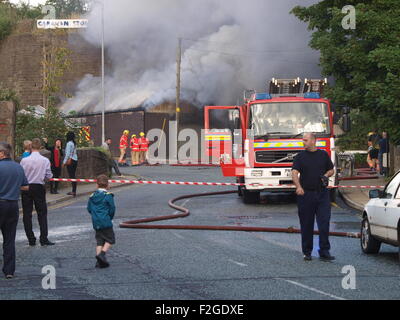 Mossley, Tameside, Manchester, Regno Unito. 18 Settembre, 2015. Un incendio si chiude la A635 Manchester Road in Mossley, Tameside vicino al Tollemache Pub. Vigili del fuoco con apparecchi respiratori frequentare la scena all Unione Garage, un'unità industriale sulla corte europea. Credito: M Kyle/Alamy Live News Foto Stock