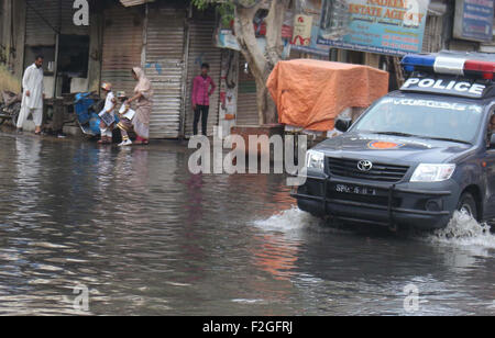 Pendolari sono passanti attraverso il ristagno di acqua di fognatura che sta creando un atmosfera antigieniche e mostrando la negligenza di KMC, in Pakistan Chowk a Karachi il Venerdì, 18 settembre 2015. Foto Stock