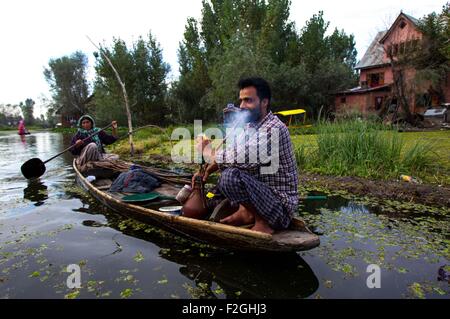 Srinagar, Indiano-controllato del Kashmir. Xviii Sep, 2015. Un pescatore del Kashmir fuma sulla sua barca in dal lago a Srinagar, capitale estiva di Indiano-Kashmir controllata, Sett. 18, 2015. © Javed Dar/Xinhua/Alamy Live News Foto Stock