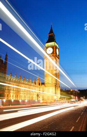 I flussi di traffico sul Westminster Bridge di notte lasciando i sentieri della luce nella parte anteriore del Big Ben e le Camere del Parlamento. Foto Stock