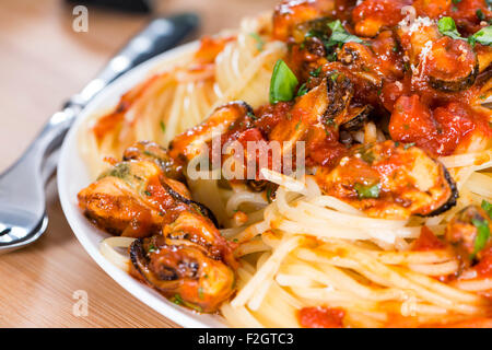 Porzione di spaghetti con le cozze in una fresca fatta di sugo di pomodoro Foto Stock