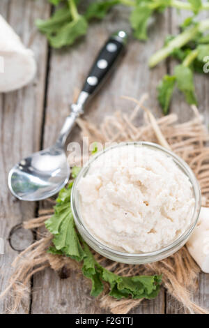 Salsa di rafano in una piccola ciotola su sfondo di legno (close-up shot) Foto Stock