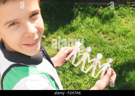 Bambino tenere la carta fatta di persone nelle figure. Figure dipinte. Foto Stock