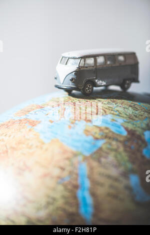 Vintage bus VW sul globo terrestre. Concetto in miniatura Foto Stock