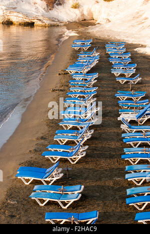 Blue chaise longue sulla sabbiosa spiaggia di Cipro a sunrise. I governatori beach. Cipro. Foto Stock