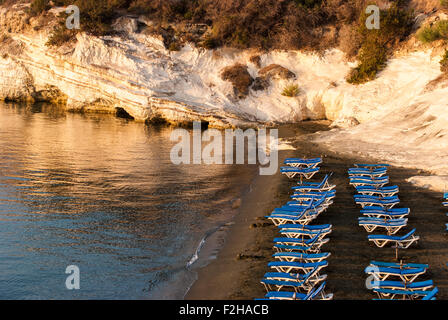 Blue chaise longue sulla sabbiosa spiaggia di Cipro a sunrise. I governatori beach. Cipro. Foto Stock