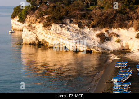 Blue chaise longue sulla sabbiosa spiaggia di Cipro a sunrise. I governatori beach. Cipro. Foto Stock