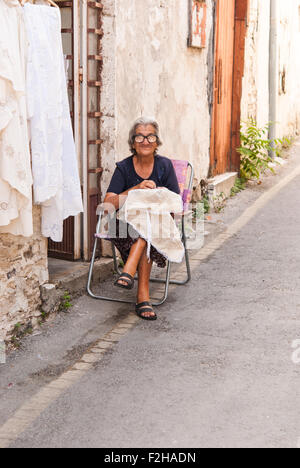 Vecchia donna ricamare lefkaritika (tradizionali pizzi fatti a mano) accanto al suo negozio di Lefkara. Cipro. Foto Stock