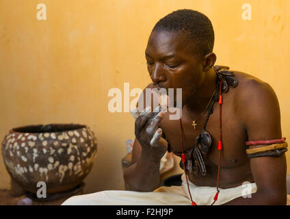 Il Benin, Africa Occidentale, Bonhicon, kagbanon bebe sacerdote voodoo leccare alcuni talco in polvere nel corso di una cerimonia Foto Stock