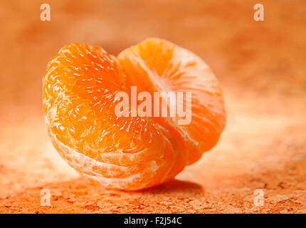 Aprire il mandarino agrumi su sfondo arancione Foto Stock