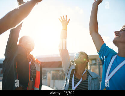 Un gruppo di giovani atleti per celebrare il successo mentre in piedi in un huddle. Team di Successo di atleti tifo vittoria. Foto Stock
