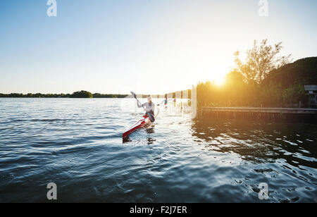 Donna in kayak il tramonto con i suoi amici Foto Stock