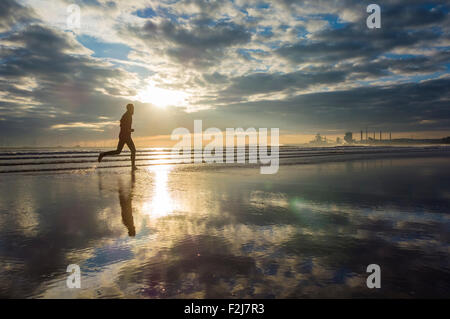 Nord Gare spiaggia vicino Seaton Carew, UK. Xx Settembre, 2015. Meteo: Early Morning jogging all alba della domenica sul Nord Gare spiaggia vicino Seaton Carew con Teesside per centrali eoliche offshore e Redcar acciaierie della distanza in distanza. Nella foto: Redcar acciaierie proprietari, SSI, ha annunciato venerdì 18 settembre 2015 che erano sospende la produzione di acciaio presso la storica Redcar stabilimento a causa dei debiti di montaggio e fallling i prezzi dell'acciaio. Circa duemila persone sono impiegate presso l'impianto. Credito: Alan Dawson News/Alamy Live News Foto Stock
