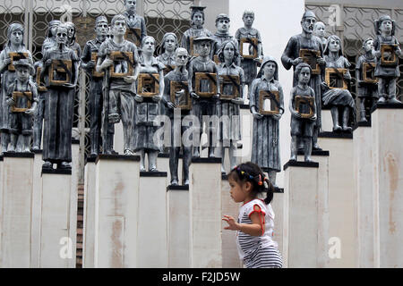 Quezon City, Filippine. Xx Settembre, 2015. Una bambina gioca nella parte anteriore delle opere d'arte di installazione visualizzate all'Università delle Filippine in Quezon City, Filippine, Sett. 20, 2015. La tecnica di installazione è realizzata nel rispetto dell'anniversario della proclamazione della legge marziale e memorializes vittime di sparizioni forzate o 'desaparecidos'. © Rouelle Umali/Xinhua/Alamy Live News Foto Stock