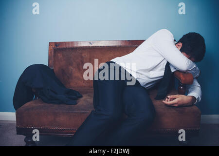 Imprenditore stanco sul divano Foto Stock
