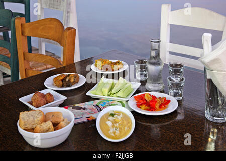 Tavolo con tradizionale cretese e alimentare il raki, il tradizionale cretese drink presso la taverna nella città di Ierapetra, Lassithi, Creta, Grecia Foto Stock