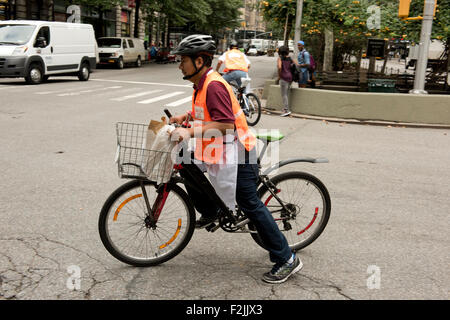 Un ristorante deliveryman borse e zaini di cibo su una bicicletta a Manhattan, New York City Stato di New York, U.S.A. Foto Stock