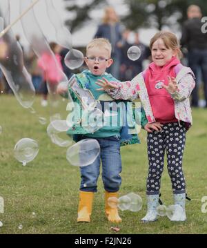 Poco Hayfield DERBYSHIRE REGNO UNITO XX Settembre 2015 un ragazzo e una ragazza giocare con bolle all'annuale Hayfield Paese mostrano . Hayfield Paese mostrano Derbyshire UK Credit: Giovanni friggitrice/Alamy Live News Foto Stock