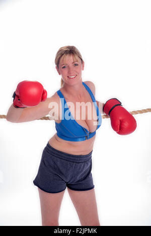 Attraente boxer femmina appoggiata sulle corde di un anello di inscatolamento Foto Stock