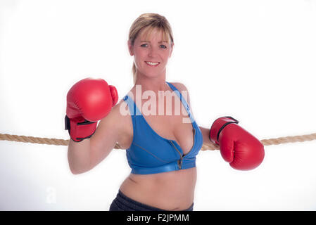 Attraente boxer femmina appoggiata sulle corde di un anello di inscatolamento Foto Stock