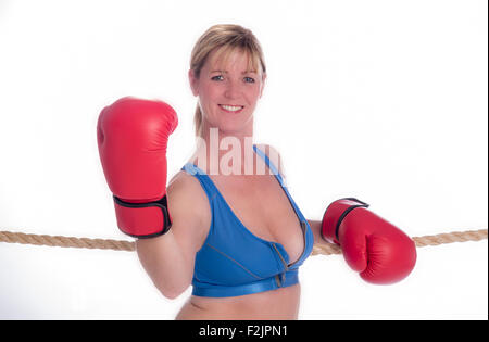 Attraente boxer femmina appoggiata sulle corde di un anello di inscatolamento Foto Stock