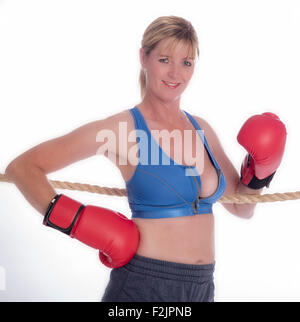 Attraente boxer femmina appoggiata sulle corde di un anello di inscatolamento Foto Stock