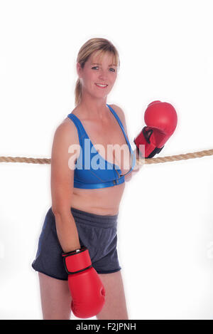 Attraente boxer femmina appoggiata sulle corde di un anello di inscatolamento Foto Stock