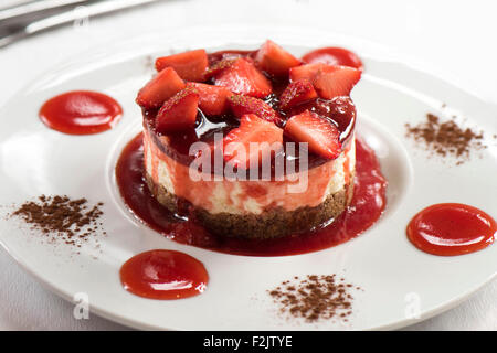 Un rosso Strawberry Cheesecake dessert servito in un ristorante italiano. Foto Stock