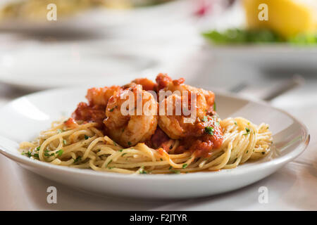 Pasto del re italiano i gamberi in salsa di pomodoro su spaghetti servita su piastra in un ristorante italiano. Foto Stock