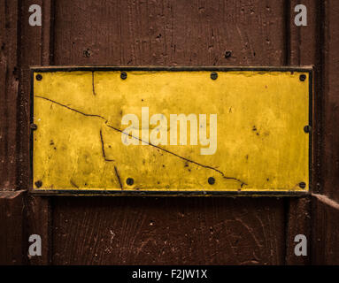 Un Grungy cartello giallo su una porta di legno per il testo Foto Stock