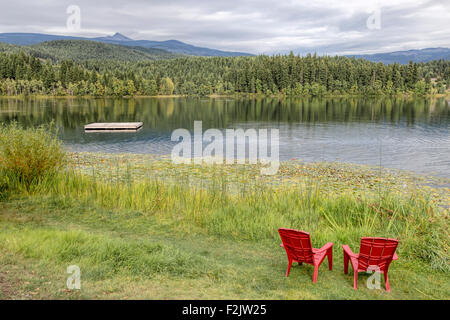 Sedie rosse con vista panoramica sul bellissimo lago olandese in Clearwater, British Columbia, Canada, America del Nord. Foto Stock