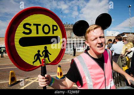 Un mouse eared lollipop uomo imbrancandosi i visitatori attraverso la strada di Banksy Dismaland del parco a tema attrazione di Weston super Mare Regno Unito Foto Stock