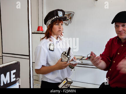 Una guardia di sicurezza allegramente accoglie un membro del pubblico a Dismaland - Banksy bemusement park in Weston super Mare Regno Unito Foto Stock