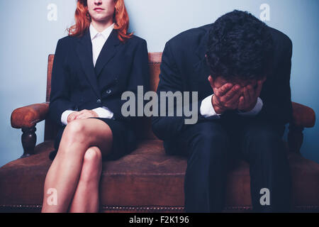 Fiducioso imprenditrice e pianto imprenditore sul divano Foto Stock