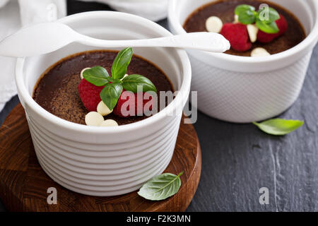 Pentole di cioccolato de creme dessert in ramekins con lamponi Foto Stock