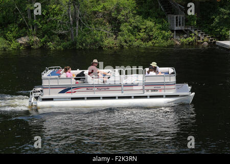 Pontoon deck barca con amici di famiglia persone a bordo. Lungo il lago di New York STATI UNITI D'AMERICA US America Adirondack State Park Foto Stock