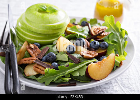 Fresca insalata sana con foglie verdi, prugne, noci e Apple Foto Stock